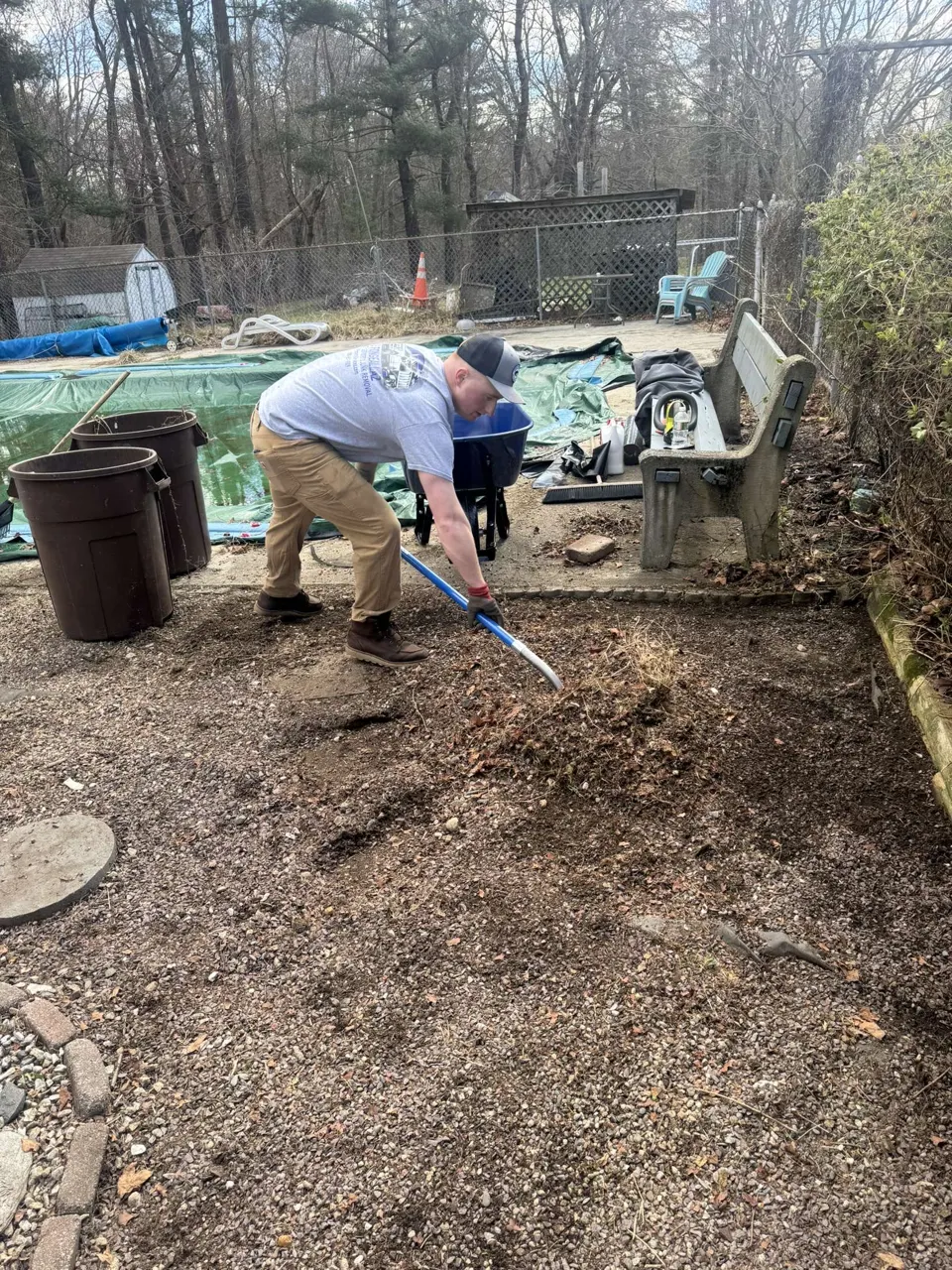 JF Property Services cleanup work with a team member raking an outdoor area